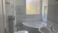 Badezimmer mit Wanne und Tageslichtfenster